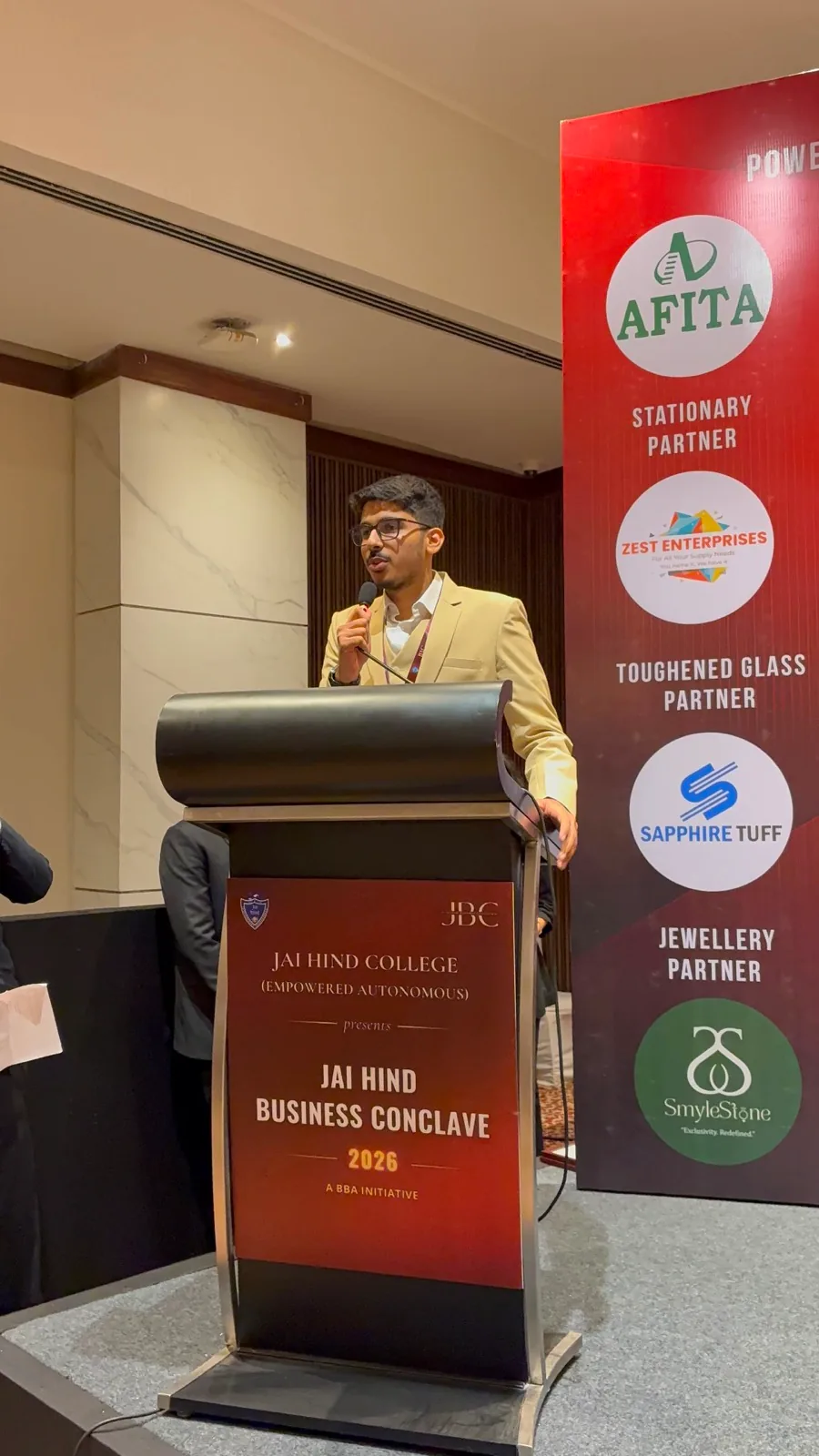 Hamza Bamboat speaking at the lectern during the Jai Hind Business Conclave 2026 at the Taj President, Mumbai